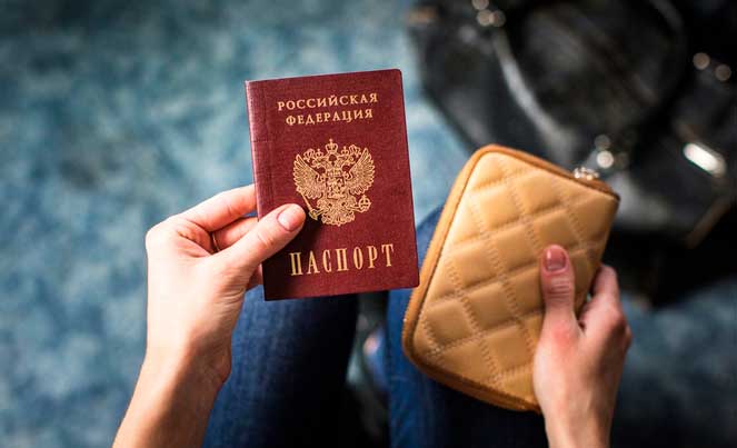 девушка держит в руках паспорт и кошелек